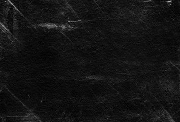 Old black stucco wall with white scratches and scuffs texture. textured grunge black board with...