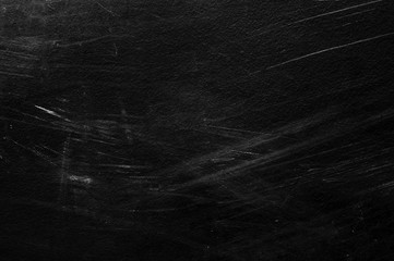 Old black stucco wall with white scratches and scuffs texture. textured grunge black board with...