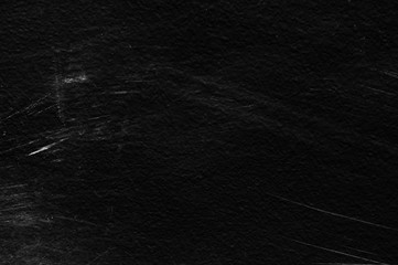 Old black stucco wall with white scratches and scuffs texture. textured grunge black board with...