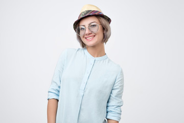 Attractive woman wearing summer hat being very glad smiling with broad smile showing her perfect teeth having fun.