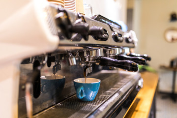 Professional coffee machine with white cup and pouring coffee drink