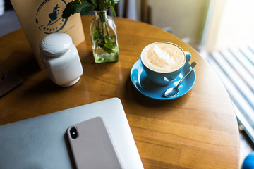 Office stuff with laptop smartphone and coffee cup. top view shot.