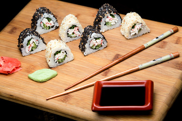 Sushi rolls with crab meat covered with sesame seeds.