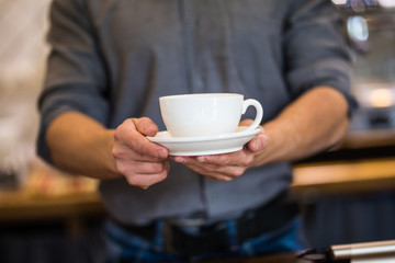 Fototapeta na wymiar Barista hands prepares cappuccino in his coffee shop. close up