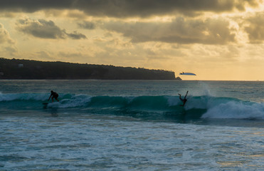 Surfers catching the wave at sunset