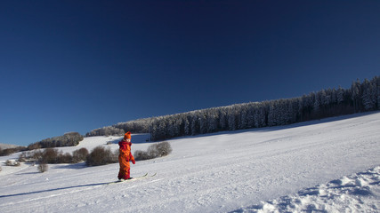Kind lernt Skifahren im Winter bei Sonne und Kälte