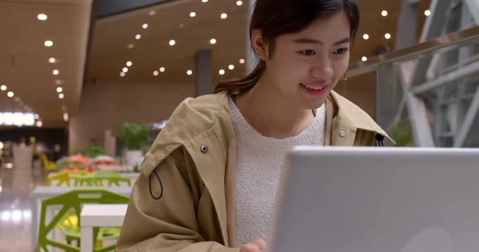 Pretty young asian woman study by the laptop indoor at library, 4k