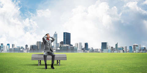 Young man in suit in park dont want to hear anything