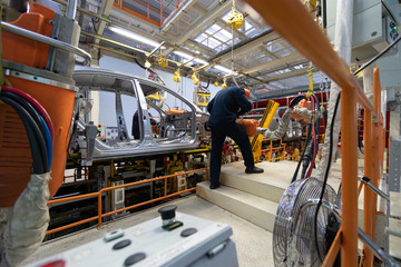 Workers assemble a vehicle body. process of welding cars. Modern Assembly of cars at the plant. automated build process of the car body