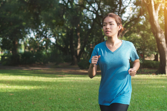 Young asian runner woman running in the park in sportswear morning time, Exercise and healthy concept, Selective focus.