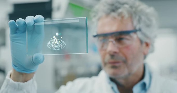 Portrait of futuristic researcher  using the augmented reality screen with hologram graphics for viewing results of his research in laboratory. Shot in 8K. Concept of futuristic medicine and science