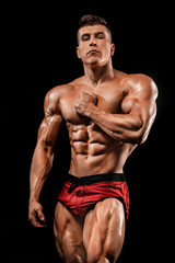 Fototapeta na wymiar Brutal strong muscular bodybuilder athlete man pumping up muscles on black background. Workout bodybuilding concept. Copy space for sport nutrition ads.