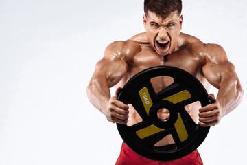 Brutal strong muscular bodybuilder athletic man pumping up muscles on white background. Workout bodybuilding concept. Copy space for sport nutrition ads.