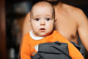 Newborn boy in the arms of father. Dad holds his little son