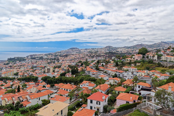 Fototapeta na wymiar Panorama view at traditional houses against blue cloudy sky on Madeira island