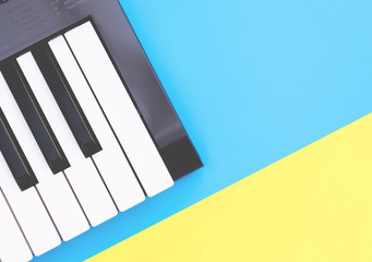 Fototapeta na wymiar Music keyboard synthesizer instrument on blue yellow copy space for Music poster concept