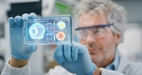 Portrait of futuristic researcher using the augmented reality screen with hologram graphics for...