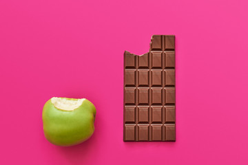 Dieting or good health concept.You have to choose between apple and chocolate