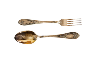 Silver cutlery set with fork, knife and spoon isolated on a white background.