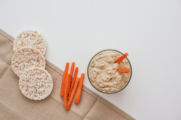 Hummus with carrot sticks. Top view oh humus with carrot isolated on white background.