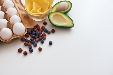 Obraz na płótnie Canvas Avocado, dry berries, eggs and cheese, we are ready to write a new healthy recipe