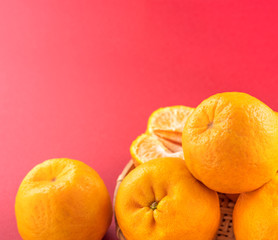 Beautiful and delicous tangerine isolated on red background with bamboo sieve, new modern auspicious and jubilant concept of chinese new year, close up, copy space