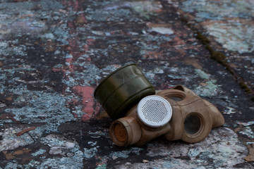 The old gas mask lies on a destroyed concrete floor, a symbol of the horrors of nuclear war and...