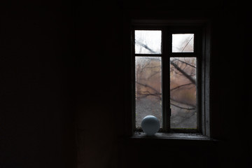 View from the window in an abandoned house through the wet glass at the trees.