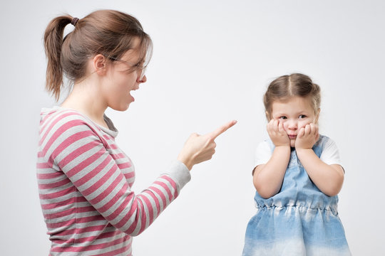 Young Mother Scold Her Daughter. Little Girl Covering Her Face With Hands. Problems Between Parents And Their Children.