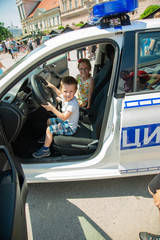 Novi Sad, Serbia - May 27, 2018: The boy and girl is sitting on a police car on Police Day marked in Novi Sad.