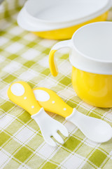 Set of yellow empty dishes for baby. Tableware for the first feeding, soft focus background