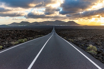 Long empty endless famous road in the volcanic area Timanfaya National Park, Lanzarote, Canary...