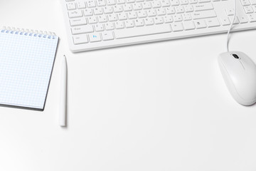 Modern white office desk table with computer keyboard and supplies. Top view with copy space, flat...
