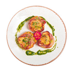 plate of bacon wrapped scallops in neat rows on a light colored plate