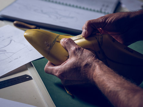 Crop shoemaker taking measurements on the shoe