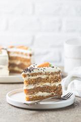 Healthy homemade carrot cake with cream cheese frosting on light stone background