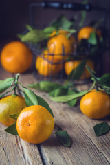 Mandarins with green leaves. Tangerines close-up on a wooden background. Background tangerines