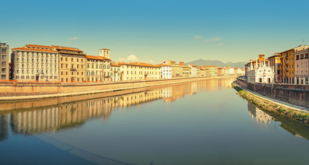 Fototapeta na wymiar Wide panoramic view of the embankment of The Arno River in Pisa. Travel in Italy and Tuscany concept