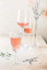Different shapes of glasses of rose wine on light background.