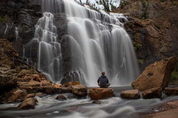 woman sitting on a rock in front of Mackenzie Falls