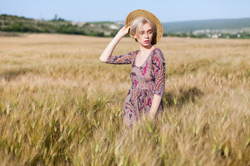 a woman farmer in hat on the field of ripe wheat harvest