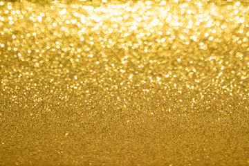 Shining gold glitter background. Abstract texture with bokeh effect.