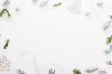 Fototapeta na wymiar Christmas composition. Spruce branches, xmas tree, xmas silver decor holiday ball with ribbon on white background.