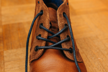 close up of old brown leather shoe on wooden background