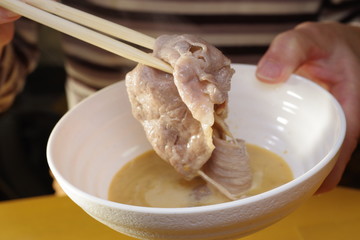 軽く茹でた牛肉をゴマダレに浸けて食べている
