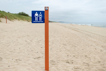 Sign on a pole on beach allowing swimming