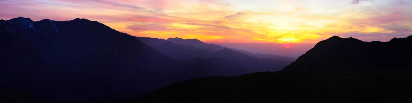 contrasting sunset high in the mountains panorama