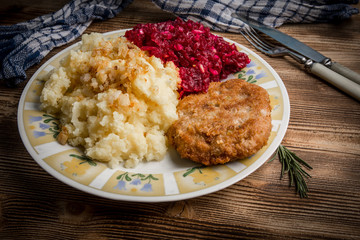 Pork cutlet with minced meat served with boiled potatoes and beetroot.