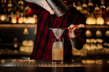 Bartender pouring a Lemonade cocktail from the steel shaker