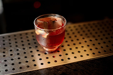 Glass of a Vieux Carre cocktail on the steel bar counter
